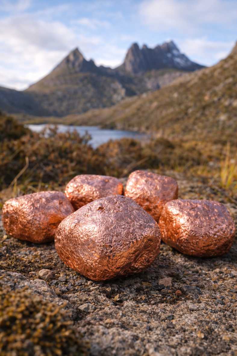 Copper plated Wombat Nuggets photographed with a Tasmanian alpine lake and mountain background
